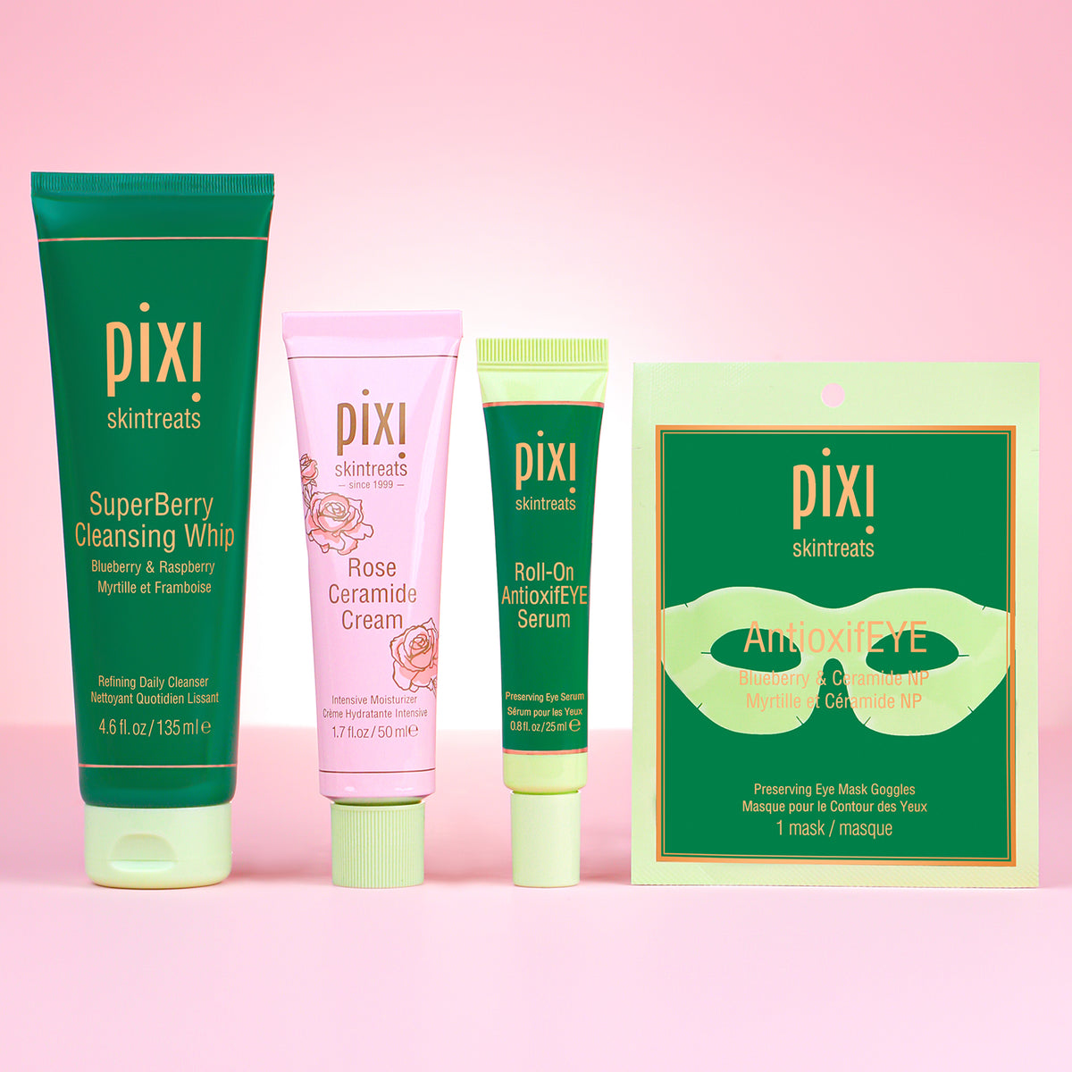 Pixi skincare products including cleansing whip, cream, serum, and eye mask on a pink background