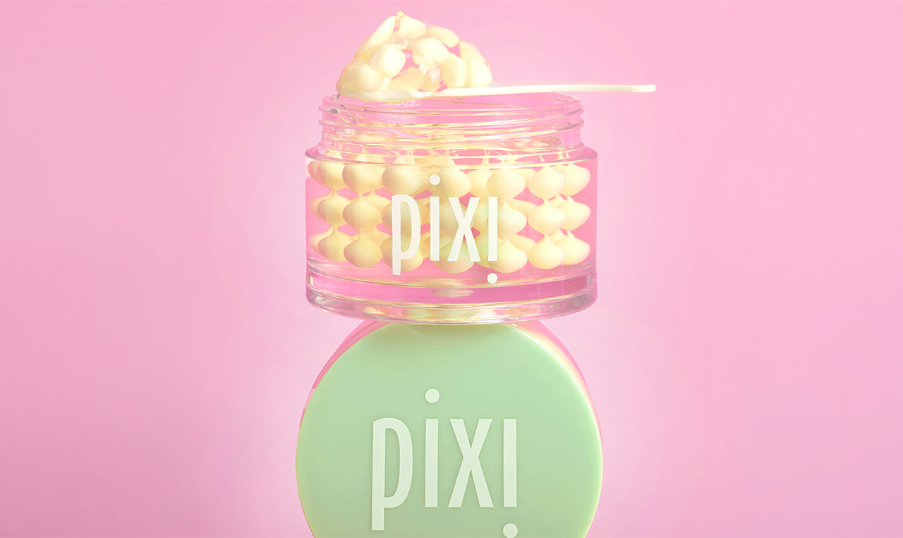 Pixi Vitamin-C CreamSerum product with pink lid and green cap on a pink background